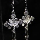 Sinner silver earrings, featuring a large cross charm with gothic details.