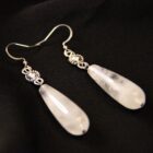 Stainless steel witchy earrings with a large teardrop shaped white crystal