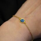 Delicate minimalist witchy stainless steel bracelet in gold with an evil eye charm