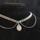 Silver choker with different layered chains and a sacred pendant